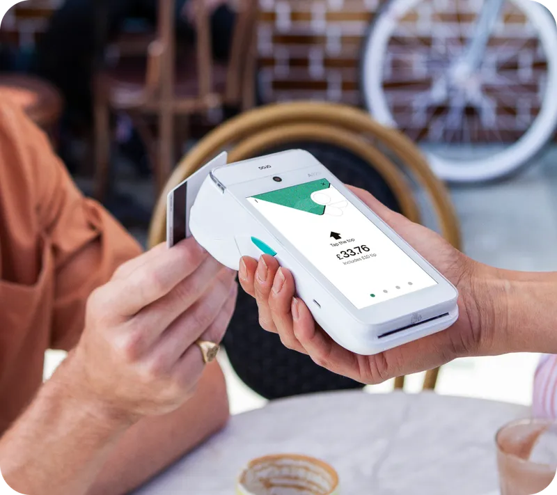 Café staff member taking a contactless payment from a customer
